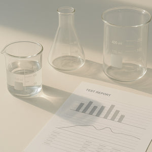 Laboratory beakers beside a printed water test report