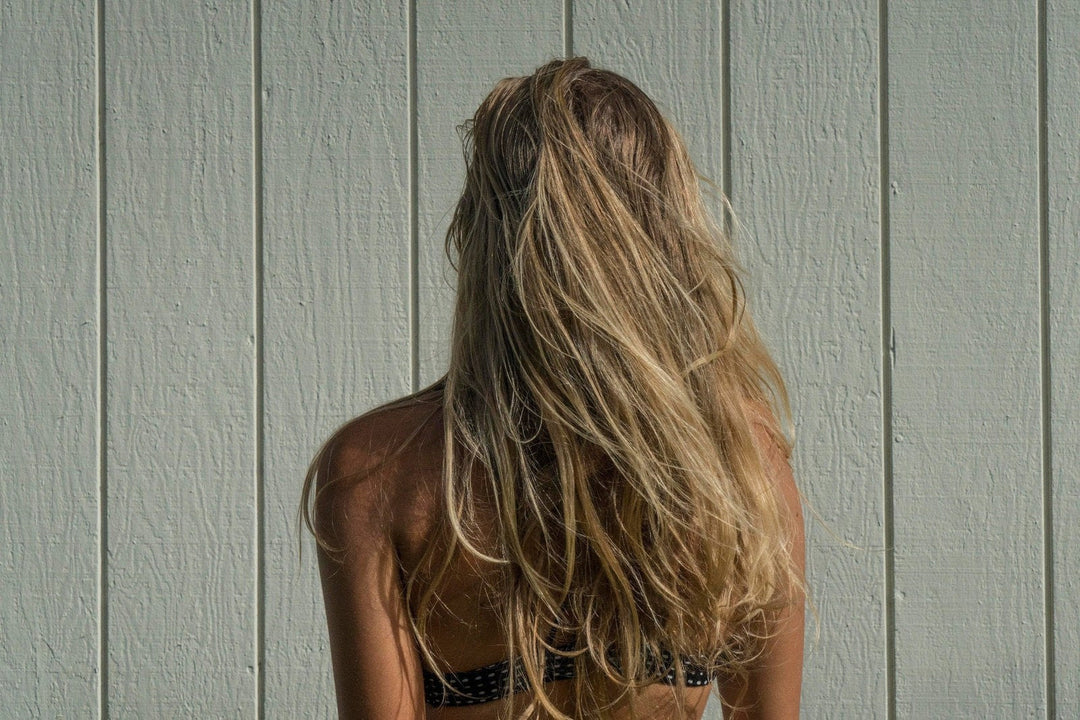 Long wavy blonde hair seen from behind, illustrating how hard water affects hair texture