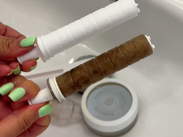 PICKI NIKI sediment cartridge: a new white one next to one after use, brown with the rust and pipe debris it caught